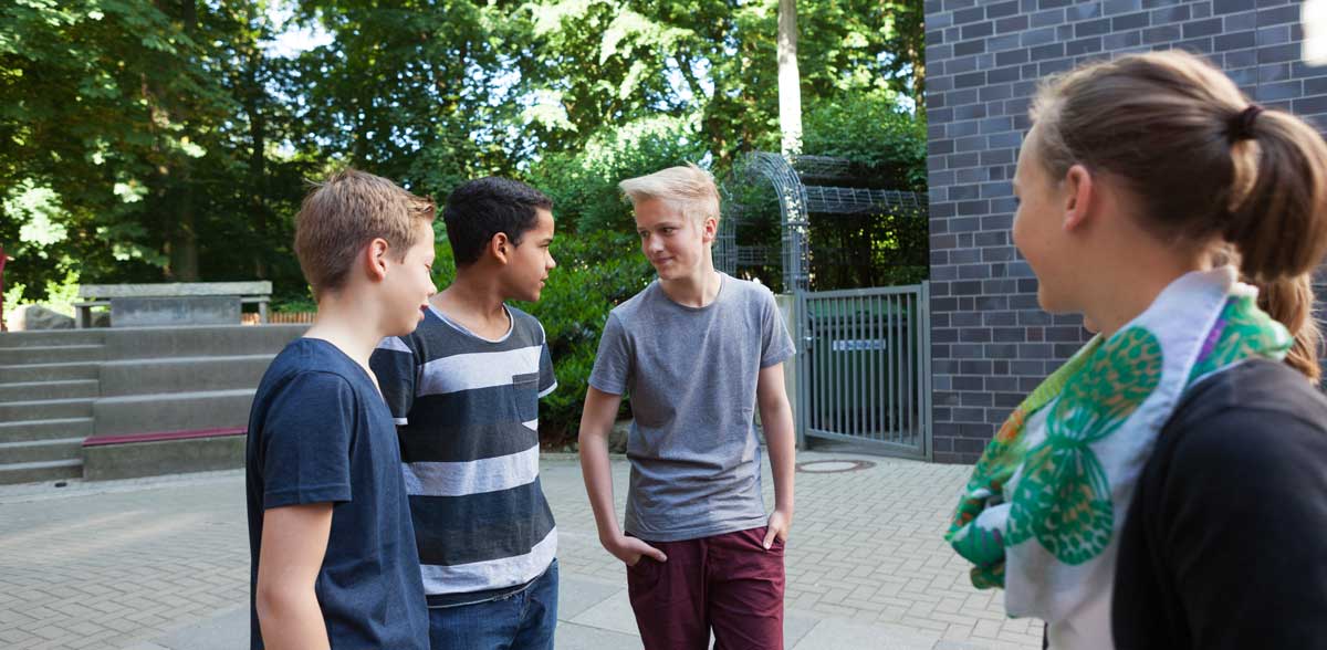 Ein Mädchen legt in einer Kirche den Arm auf die Schulter eines Freundes.